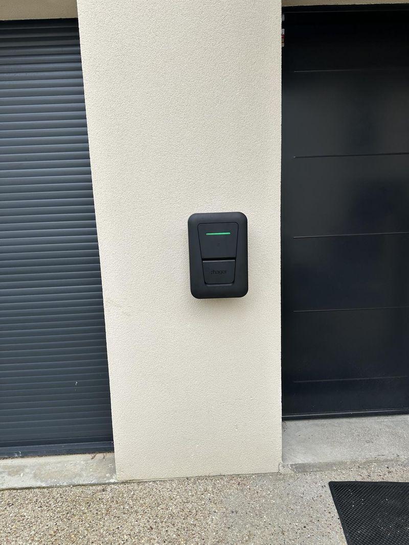 Borne de recharge murale à côté d'une porte de garage – Arpajon et alentours